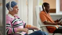 Individuals sitting in chairs and getting chemotherapy at an infusion center.